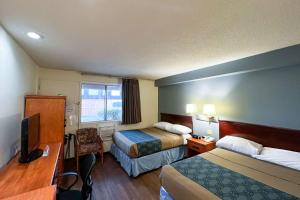 卡尔加里伊科诺村汽车旅馆 的酒店客房配有两张床和一张书桌