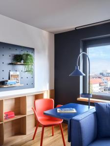 沃尔夫斯堡STAYERY Wolfsburg City的客厅配有蓝色桌子和红色椅子