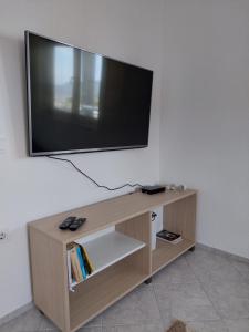 巴尔Apartments Tramonto的木制电视架上配有平面电视