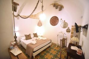 加利波利L'Antica Rimessa Da Gigi的卧室配有一张床,墙上挂着一个钟