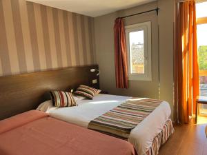 马德里劳斯考罗纳尔斯旅馆的一间卧室设有一张床和一个窗口