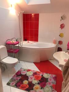 采西斯浪漫玫瑰酒店的带浴缸和卫生间的浴室,并种植了鲜花。