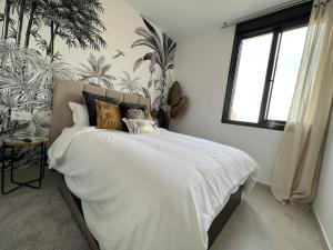 马尔德·克里斯塔尔Outstanding 2 bed apartment with rooftop sea views的一间卧室配有白色床单和热带壁纸。