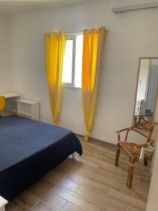圣丹尼斯La Terrasse des manguiers的一间卧室配有一张床、一把椅子和镜子