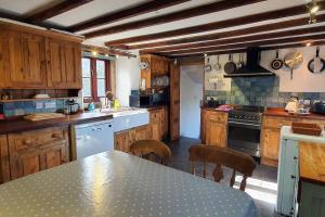 EltonWestdale Cottage, Elton in the Peak District的厨房配有木制橱柜和桌椅