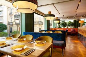 塞维利亚英伦酒店的餐厅配有木桌和椅子