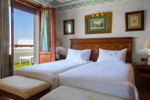 塞维利亚英伦酒店的一间卧室设有两张床和大窗户