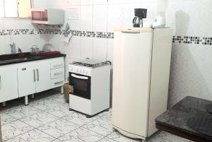 马卡埃Apto Aeroporto Macae的厨房配有白色冰箱和炉灶。