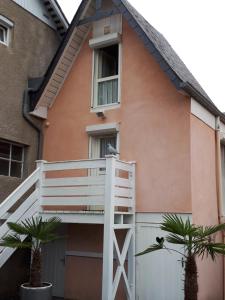 巴涅尔德比戈尔Résidence Ana的白色阳台和两棵棕榈树的房子