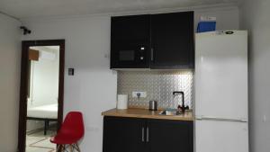 阿尔赫西拉斯Convenient Rooms - Ferry, Train & Bus Station -的厨房配有冰箱和红色椅子