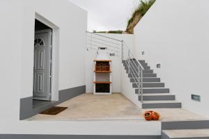大里贝拉Village House的白色的房子,地面上设有楼梯和南瓜