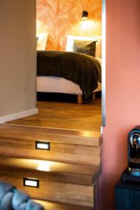 罗登德伦特的武器酒店的铺有木地板的客房内设有一间卧室和一张床。