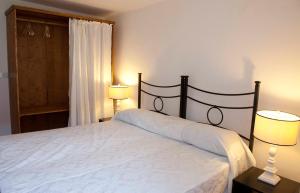 阿奎莱亚Ca' Marisa Aquileia的一间卧室配有一张带两盏灯的床和一扇窗户。