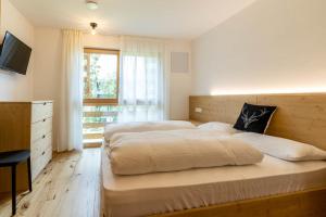 圣洛伦佐-迪塞巴托Casa Erika的一间卧室设有两张床、一台电视和一扇窗户。