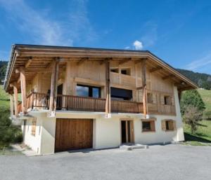 梅杰夫Cozzy appart dans chalet vue Mont-Blanc 2 chambres的带阳台和车库的大型木屋