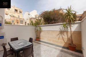 埃尔哥茨拉Comfy APT with Terrace, 5 mins to Sliema Ferries by 360 Estates的植物阳台的桌椅