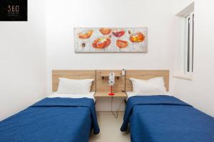 埃尔哥茨拉Comfy APT with Terrace, 5 mins to Sliema Ferries by 360 Estates的配有蓝色床单的客房内的两张床