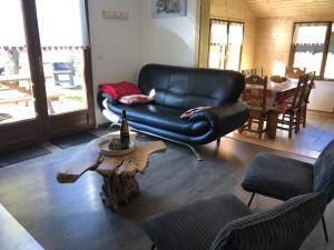 克松吕-隆日梅Chalet CHLOE - jusque 6 pers - Xonrupt Longemer的客厅配有真皮座椅和咖啡桌