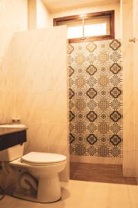 高兰海水阳光简易别墅酒店的一间带卫生间和瓷砖淋浴的浴室