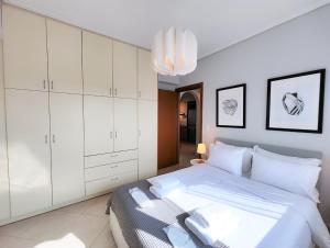 雅典Nefelis C2 by Verde Apartments的一间卧室配有一张带白色橱柜和吊灯的床。