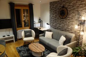 布里昂松Chez petit Louis- Appart centre ville jusqu'à 6 personnes的带沙发和砖墙的客厅