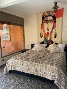 TagadirtJnane Nina的卧室配有一张带女性绘画的床