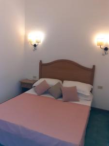 费拉约港RESIDENCE TERME ISOLA D'ELBA SRL的卧室配有一张大床,墙上有两盏灯