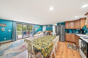 Brant LakeRiver Retreat的厨房、带桌子的用餐室以及带蓝色墙壁的厨房。