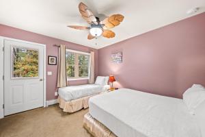 Brant LakeRiver Retreat的一间卧室配有两张床和吊扇