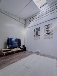 马六甲The Cozy Place by Nestcove的客房设有平面电视和桌子。