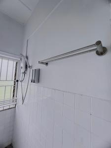 马六甲The Cozy Place by Nestcove的浴室铺有白色瓷砖,设有淋浴。