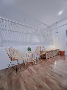 马六甲The Cozy Place by Nestcove的白色墙壁的客房内配有两把椅子和一张桌子