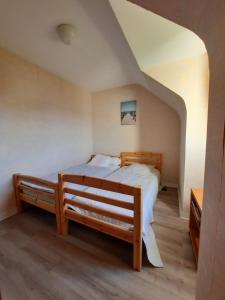 勒克鲁西克Le Croisic Brocéliande的一间卧室配有一张床,卧室配有长凳