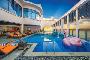 岘港Luxury Beach Condo 5-star, Rooftop pool的一座室内游泳池,位于一座建筑中,设有可充气的火烈鸟