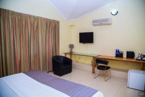 阿克拉禁区酒店的酒店客房配有一张床、一张书桌和一台电视。