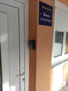 斯拉沃尼亚布罗德Apartman NADA的门旁墙上的蓝色标志