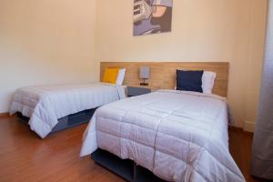 奥里萨巴Hostal 170的一间卧室配有两张床和一盏灯。