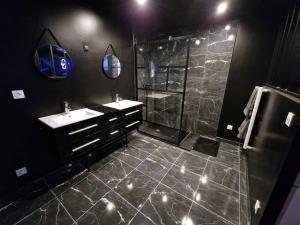 Suite Coquine avec jacuzzi YaoSpa60的黑色浴室设有水槽和淋浴