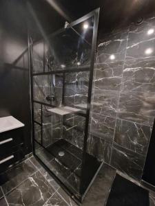 Suite Coquine avec jacuzzi YaoSpa60的带淋浴的浴室(带石墙)