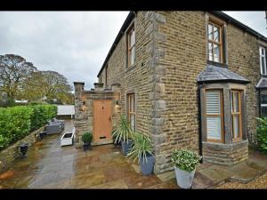 沃丁顿Luxury Waddington Cottage, Ribble Valley的砖屋,设有庭院和木门