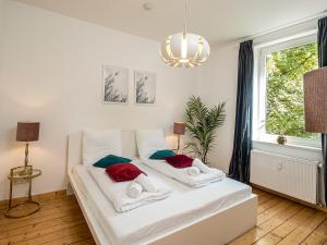杜伊斯堡Fabelhafte Apartments zum wohlfühlen mit JUNIK Apartments的窗户客房内的一张白色床
