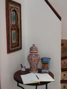 杰迪代Riad Siham的一张桌子,上面有一本书和一个花瓶