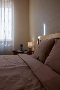 陶格夫匹尔斯Olimpija Hotel & SPA的一间卧室配有一张床和一扇带灯的窗户