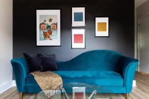 夏洛特Kasa Edison House South End Dilworth Charlotte的客厅里一张蓝色的沙发,墙上挂着照片
