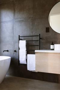 拉格伦Modern Raglan Hideaway的一间带水槽、浴缸和镜子的浴室