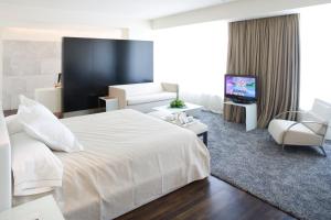 阿尔卡拉德荷那利斯阿尔卡拉赫纳雷斯汽车旅馆酒店的酒店客房设有白色的床和客厅。
