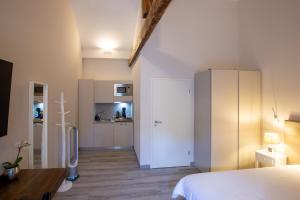 BuchillonAuberge des Grands Bois的一间带白色床的卧室和一间厨房