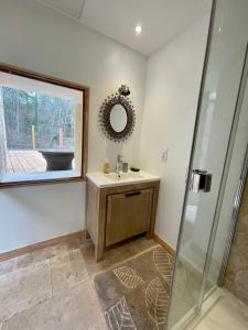 吕斯特勒La Source的一间带水槽、镜子和淋浴的浴室
