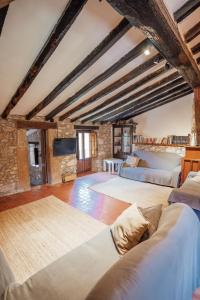 Vall de BianyaCasa Rural El Callís的阁楼卧室设有两张床和壁炉