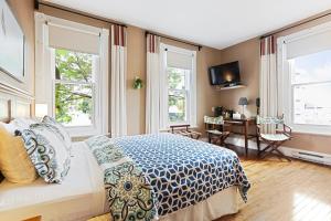魁北克市塔林城堡酒庄酒店的卧室配有一张床、一张书桌和窗户。